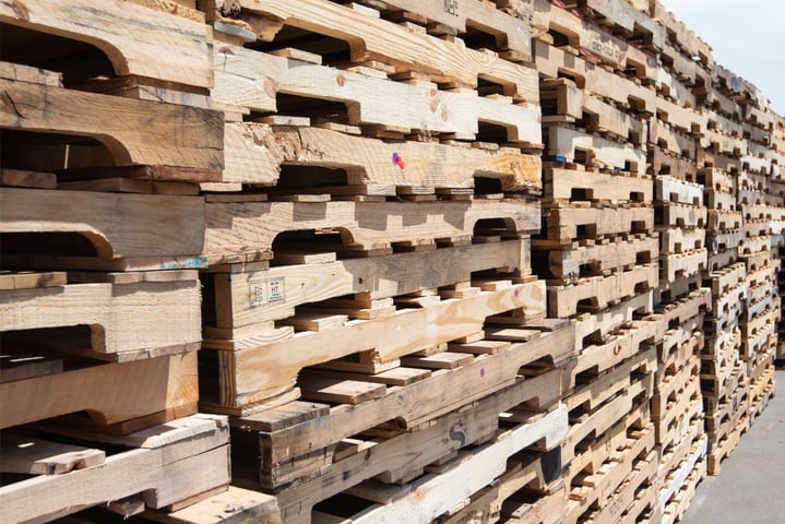 Stacks of recycled white wood pallets