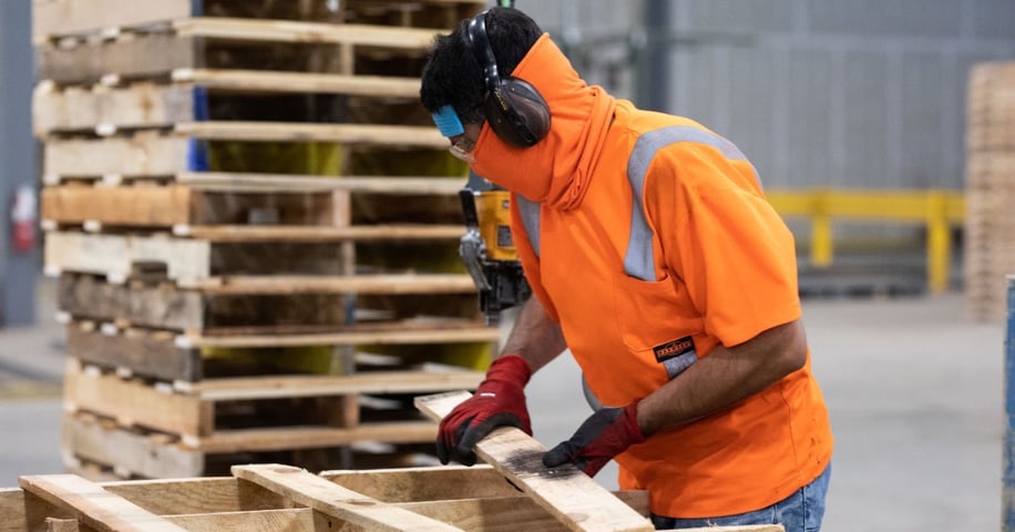 Employee repairing a wooden pallet